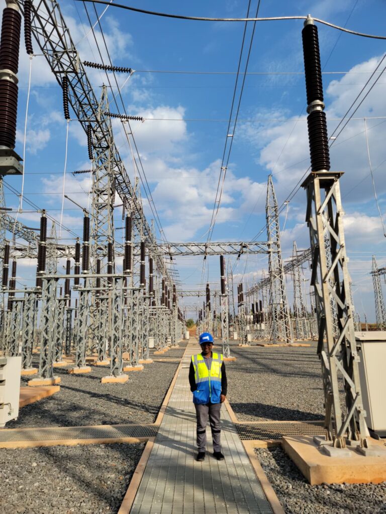 Donatille Nkunzi at electrical infrastructure at the Rusumo hydropower facility in East Africa.